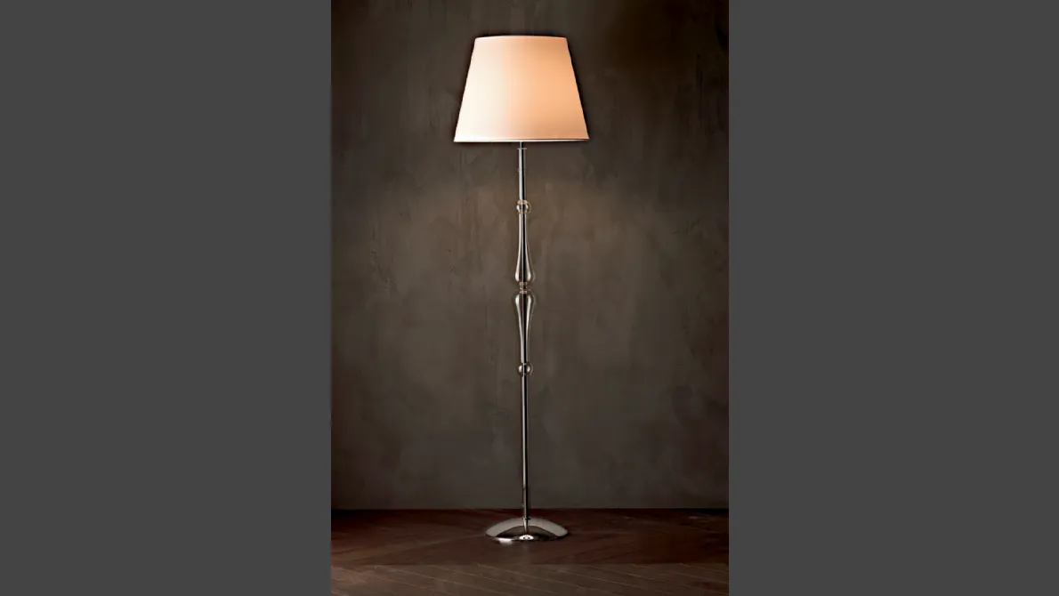 Lampada da terra Miss con struttura cromata,  stelo sagomato in pirex trasparente e paralume in tessuto di Le Fablier